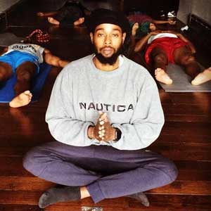 Jah Ques sitting in yoga pose