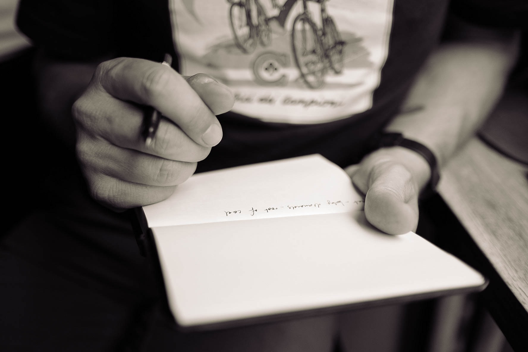 man writes in notebook